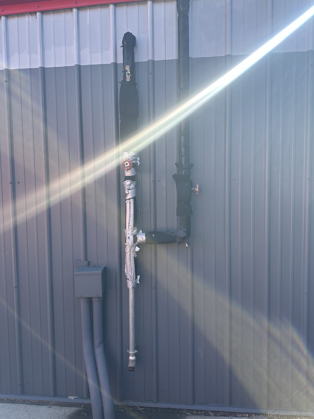 Exterior fire sprinkler piping with freeze protection measures