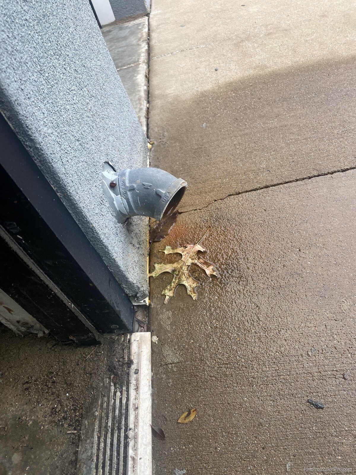 FDC drain pipe with rust staining on building exterior