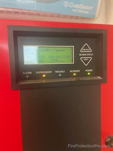 Fire alarm panel displaying SUPERVISORY: Tamper signal with alarm, supervisory, trouble, and power indicator lights