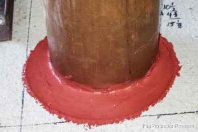 Intumescent firestop sealant applied around a pipe penetration through a fire-rated floor assembly